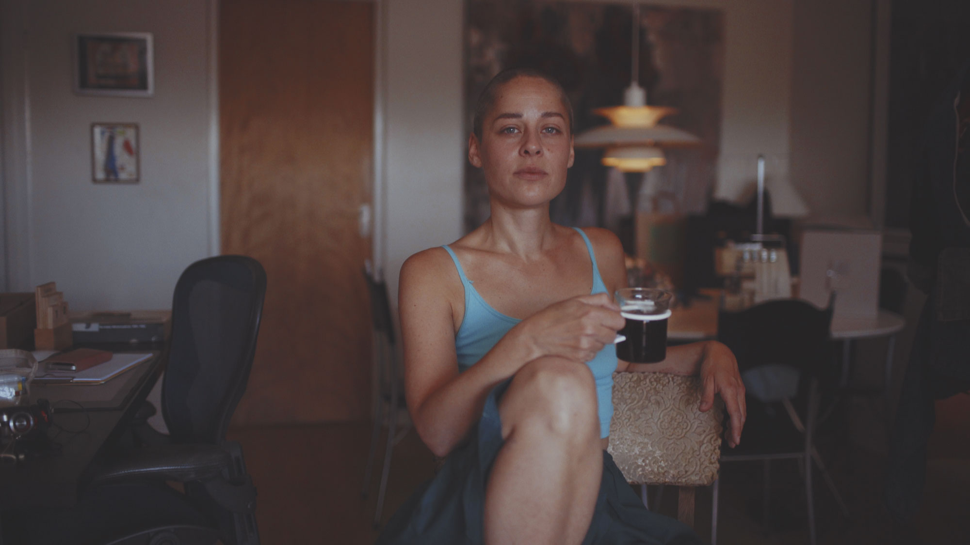 Kvinna dricker kaffe i sin lägenhet tidigt på morgonen